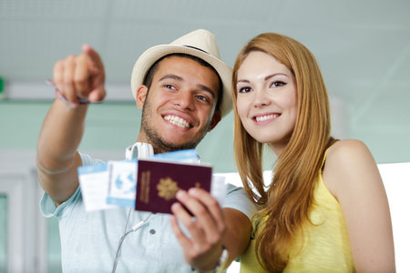 happy couple with passport pointingの写真素材