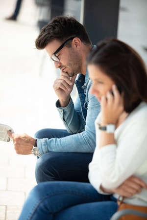 two people chatting at the bus stopの写真素材