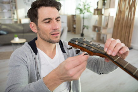 adult artisan fixing old classic guitar