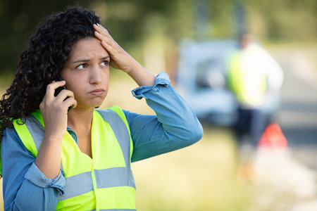 young woman with a broken car calling on mobile phone