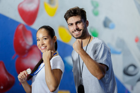 triumphant climber and coach by indoor climbing wall