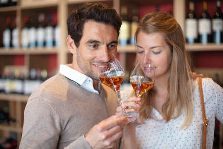 couple smelling bouquet of glass of wine in wine tastingの写真素材