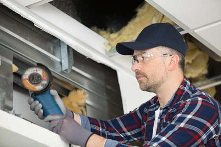 workman using angle grinder on metalの写真素材