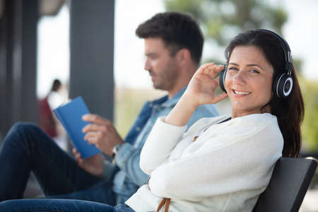 woman on a bench outdoors wearing headhonesの写真素材
