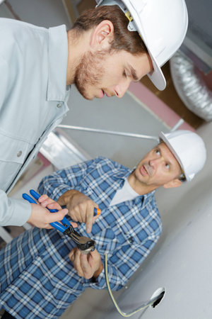 young builder cutting cable using nippers