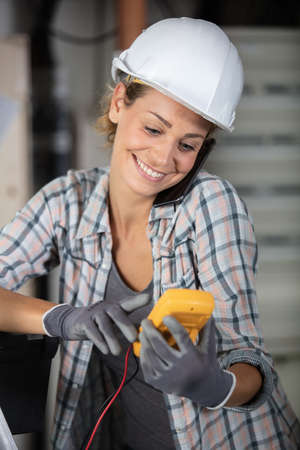 woman electricity worker controller on construction site checking electric cablesの写真素材