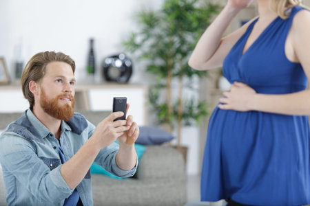 man takes a photo of pregnant womanの写真素材
