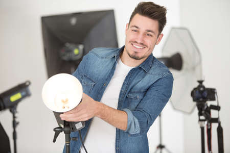 male photographer preparing his studioの写真素材