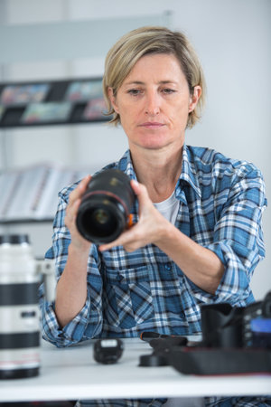 woman photographer inspecting the lens