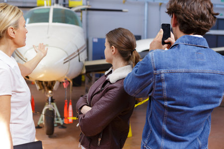 man photographing aircraft while visiting hangarの写真素材
