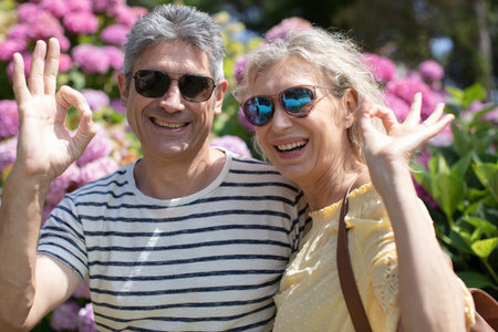 beautiful middle age couple doing ok sign