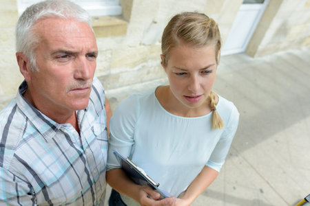 man and woman checking something outdoors