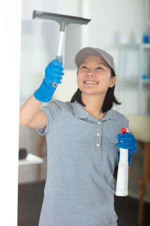 happy woman is cleaning a fake windowの写真素材