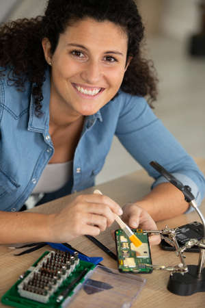 happy woman technician fixing computerの写真素材