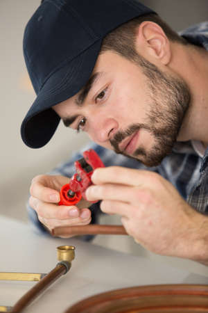 young worker using copper pipes and fittingsの写真素材