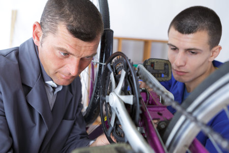 a young man repairing bicycle