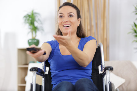 cheerful disabled woman watching television in living room
