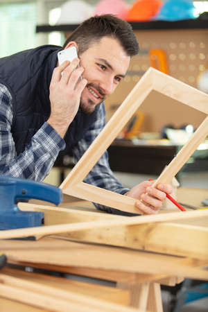 man holding picture frame and phoneの写真素材