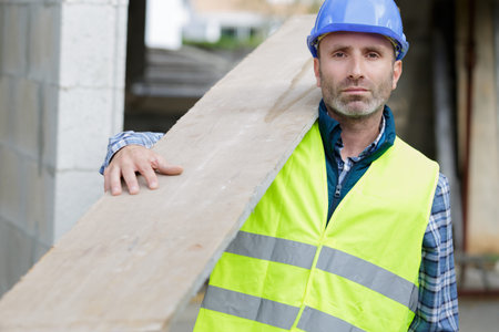 man as builder carrying wood and working
