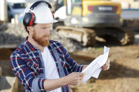 civil engineer or architect on construction site checking plan