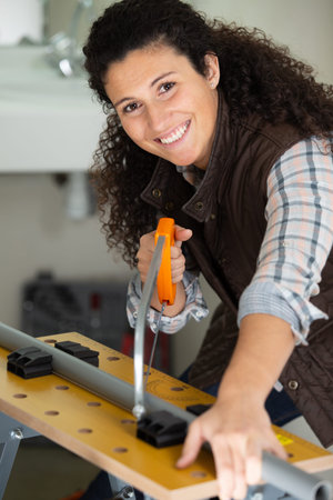 a happy woman using a hacksaw