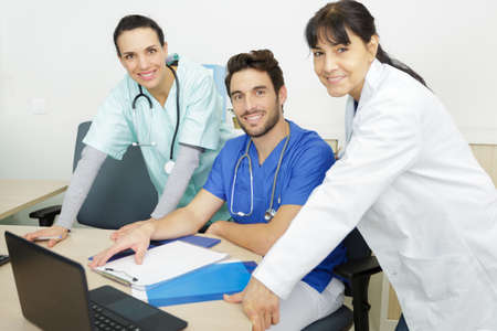 a team of three young doctors smiling cameraの写真素材