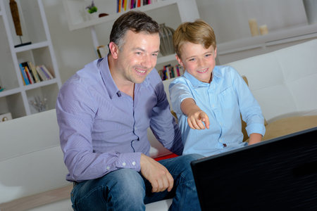 Adult and young child watching television