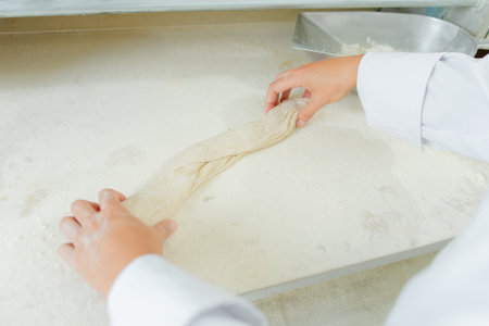 hands are rolling a bagette
