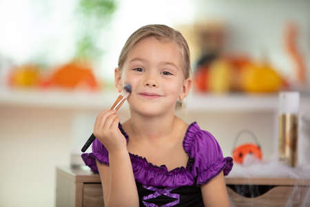 cute smiling little girl with makeup brushの写真素材