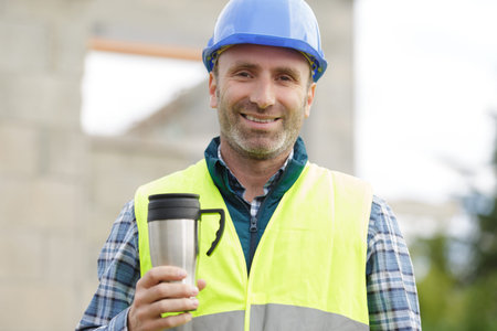 builder wearing with takeaway coffee