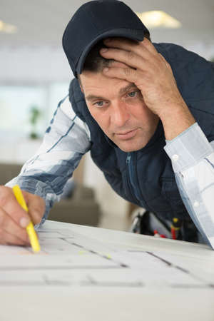 man with a pencil writes down results on planの写真素材