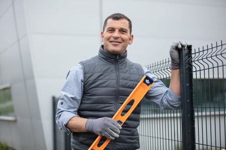 happy builder leveling a fence