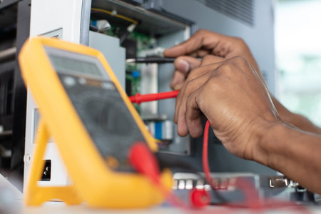 cropped view of technician testing computer with a multimeterの写真素材