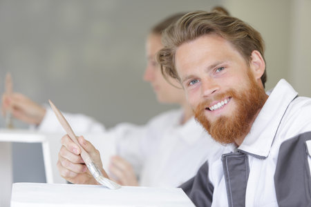a male carpenter painting woodの写真素材