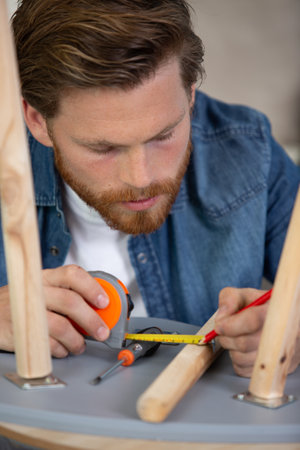 furniture production maker in workshop making wooden chairの写真素材