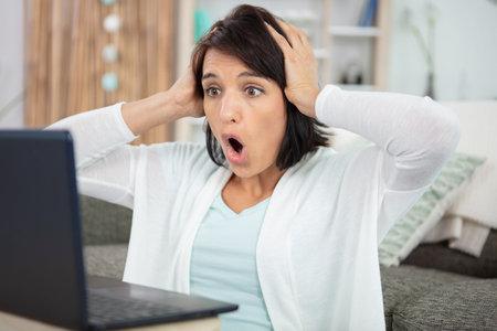 portrait young shocked business woman sitting in front of laptop