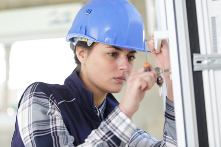 female locksmith holding screwdriver and keysの写真素材