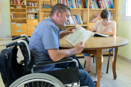 man in wheelchair in the libraryの写真素材