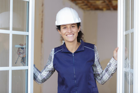 happy female builder opening the windowの写真素材