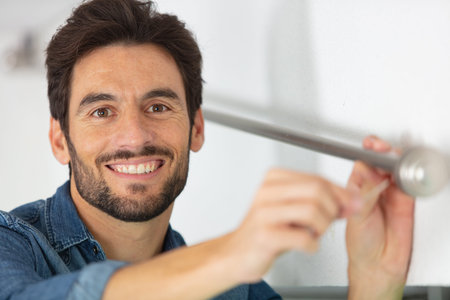 man checking bracket for curtain railの写真素材
