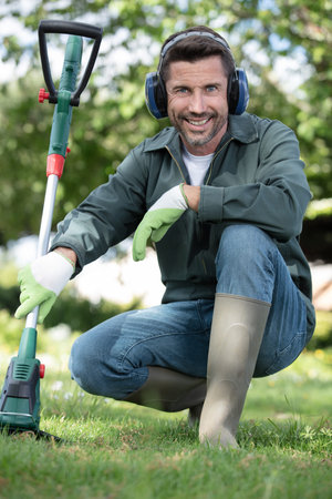 professional gardener posing with brush cutter