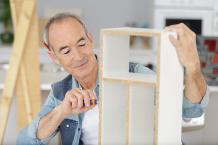male assembling flat pack furnitureの写真素材