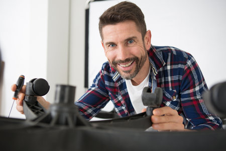 man tightening beaver on office chairの写真素材