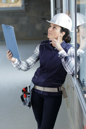female construction worker on site holding clipboardの写真素材
