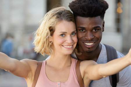 mixed couple in love taking selfie on smartphoneの写真素材
