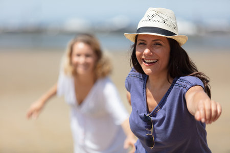 beautiful friends enjoying the beach on a sunny dayの写真素材