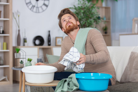 man collecting water in bucket from ceilingの写真素材