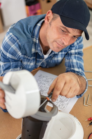 man in workshop repairing broken coffee machine