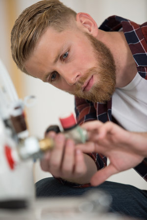 plumber working on boiler inlet pipeの写真素材