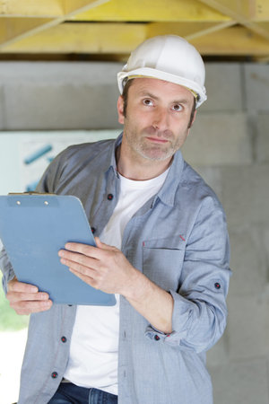 a contractor with hardhat and clipboard